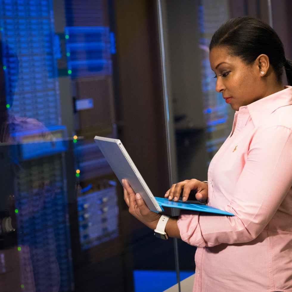 photo of woman holding a gray laptop in front of systems